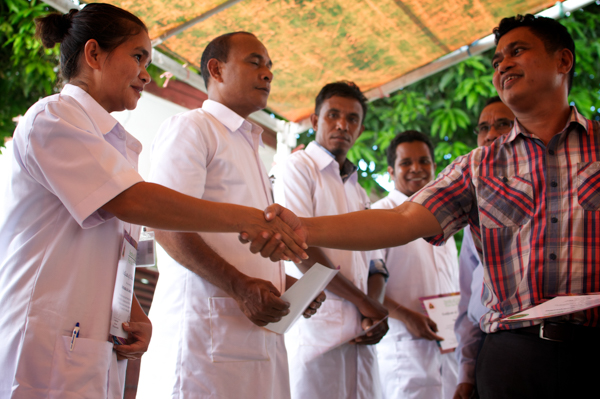 Former Minister Mariano Sabino Assanami hands Seed Officer Coordinator Dorilanda da Costa Lopes her certificate at the inauguration of the National Seed Laboratory in May 2013 © Alva Lim/Seeds of Life